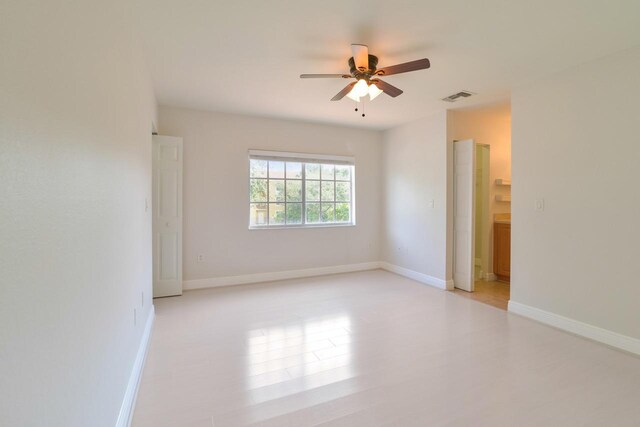 unfurnished room featuring baseboards, a ceiling fan, and visible vents