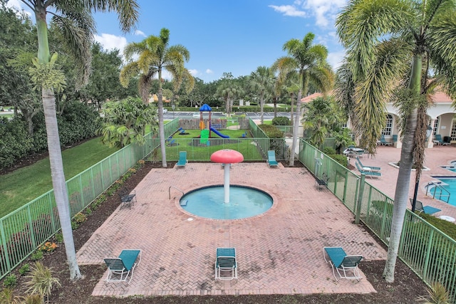 view of swimming pool with a lawn, playground community, a fenced backyard, a hot tub, and a patio
