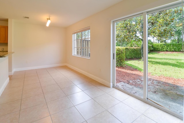 interior space featuring light tile patterned flooring, visible vents, and baseboards