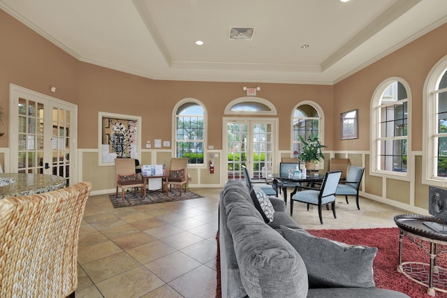 living area featuring french doors, visible vents, a raised ceiling, and crown molding
