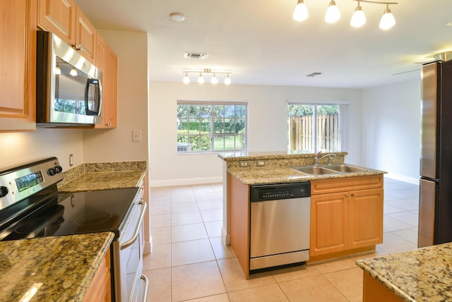 kitchen with a sink, light tile patterned floors, stainless steel appliances, light stone countertops, and visible vents