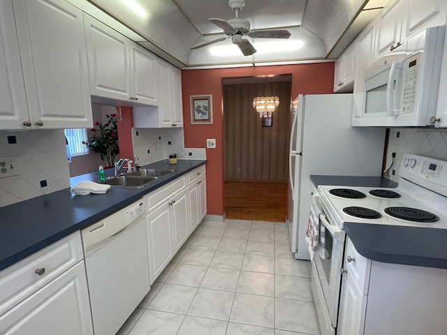 kitchen featuring ceiling fan with notable chandelier, a sink, white cabinets, and white appliances