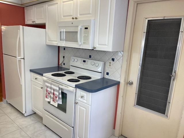kitchen with dark countertops, white appliances, decorative backsplash, and white cabinets
