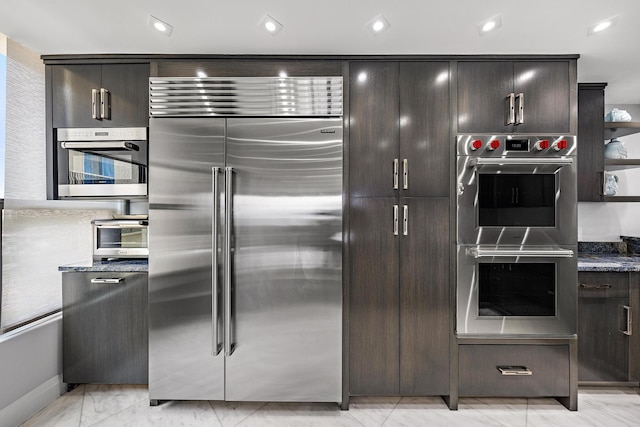 3610 S Ocean Blvd Unit 405, South Palm Beach, FL 33480 - kitchen featuring stainless steel appliances, dark brown cabinetry, dark stone countertops, recessed lighting, and baseboards