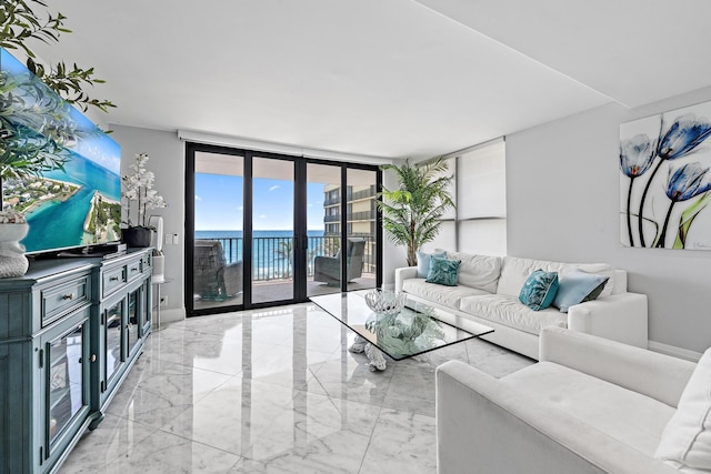 3610 S Ocean Blvd Unit 405, South Palm Beach, FL 33480 - living area with a water view, light marble finish floors, floor to ceiling windows, and baseboards