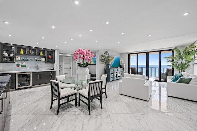 3610 S Ocean Blvd Unit 405, South Palm Beach, FL 33480 - dining area featuring wine cooler, bar with sink, light marble finish flooring, and recessed lighting