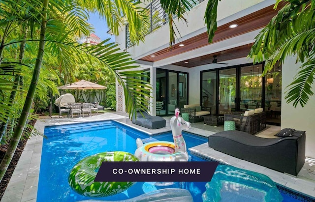 pool with a jacuzzi, a ceiling fan, an outdoor hangout area, outdoor dining space, and a patio area