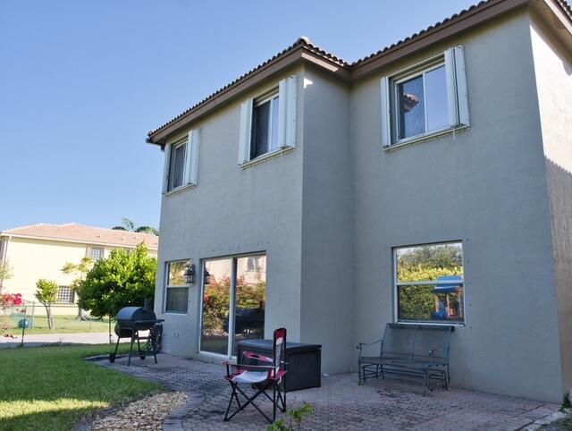 2102 Little Torch St, Riviera Beach, FL 33407 - back of house with a yard, a patio area, and stucco siding