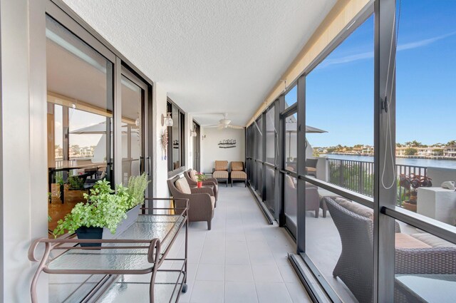 3420 S Ocean Blvd Unit 3W, Highland Beach, FL 33487 - sunroom featuring a water view, a textured ceiling, tile patterned flooring, a ceiling fan, and outdoor lounge area
