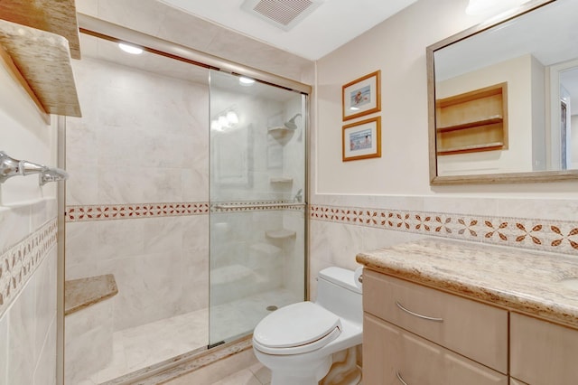 3420 S Ocean Blvd Unit 3W, Highland Beach, FL 33487 - bathroom featuring toilet, vanity, walk in shower, tile walls, and wainscoting