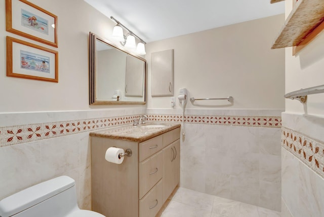 3420 S Ocean Blvd Unit 3W, Highland Beach, FL 33487 - bathroom with tile walls, wainscoting, vanity, toilet, and tile patterned floors