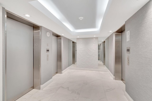3420 S Ocean Blvd Unit 3W, Highland Beach, FL 33487 - hall featuring elevator, recessed lighting, light marble finish flooring, and a tray ceiling