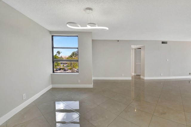 6372 La Costa Dr Unit 302, Boca Raton, FL 33433 - tiled empty room featuring a textured ceiling, baseboards, and a chandelier