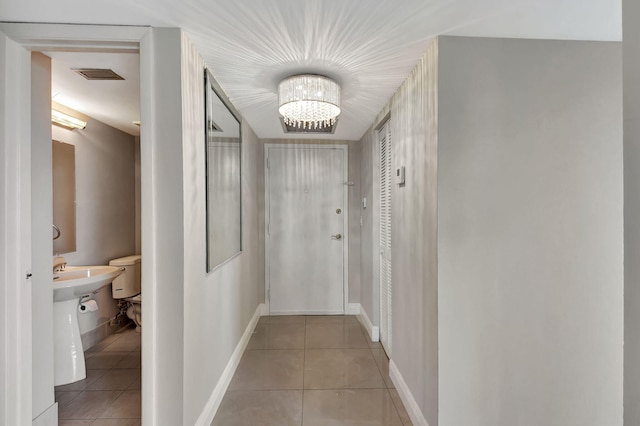 6372 La Costa Dr Unit 302, Boca Raton, FL 33433 - hallway featuring light tile patterned floors, a chandelier, and baseboards