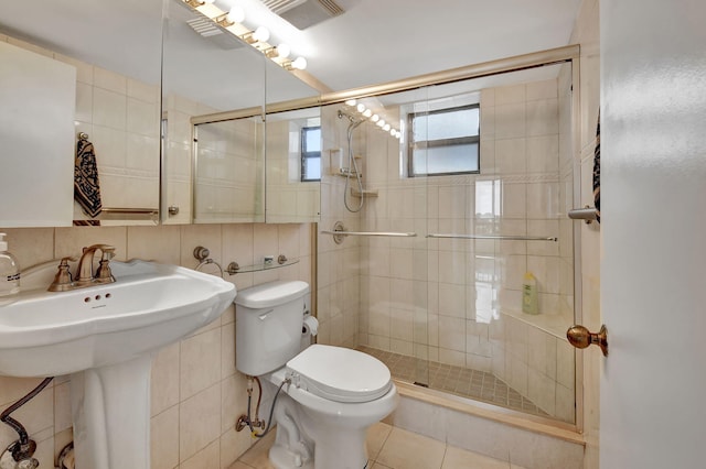 6372 La Costa Dr Unit 302, Boca Raton, FL 33433 - bathroom featuring toilet, tile walls, a stall shower, tile patterned flooring, and a sink