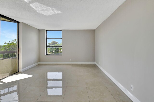 6372 La Costa Dr Unit 302, Boca Raton, FL 33433 - unfurnished room with a textured ceiling, light tile patterned floors, and baseboards