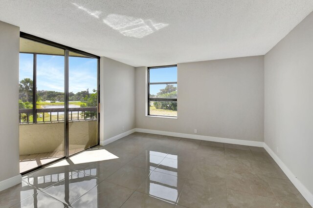 6372 La Costa Dr Unit 302, Boca Raton, FL 33433 - tiled spare room featuring a textured ceiling and baseboards