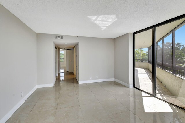 6372 La Costa Dr Unit 302, Boca Raton, FL 33433 - unfurnished room with light tile patterned floors, a textured ceiling, and baseboards