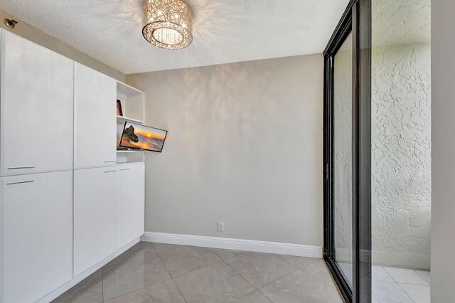 6372 La Costa Dr Unit 302, Boca Raton, FL 33433 - unfurnished dining area with a chandelier and a textured ceiling