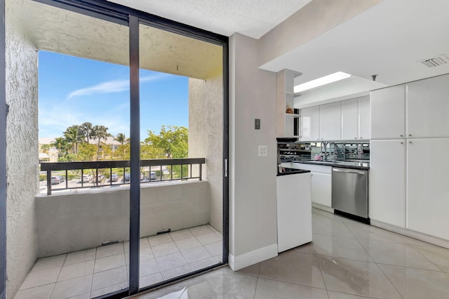 6372 La Costa Dr Unit 302, Boca Raton, FL 33433 - kitchen with dishwasher, white cabinetry, dark countertops, and light tile patterned floors