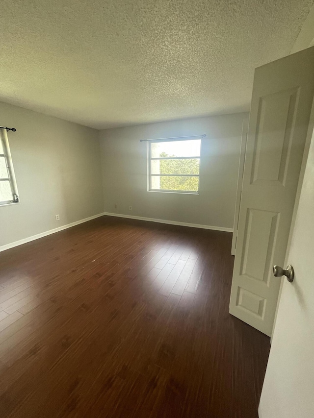 642 NW 13th St Unit 31, Boca Raton, FL 33486 - unfurnished room featuring dark wood-style floors, baseboards, and a textured ceiling