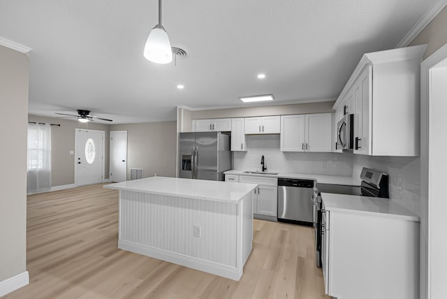 kitchen with ornamental molding, decorative backsplash, appliances with stainless steel finishes, and a sink