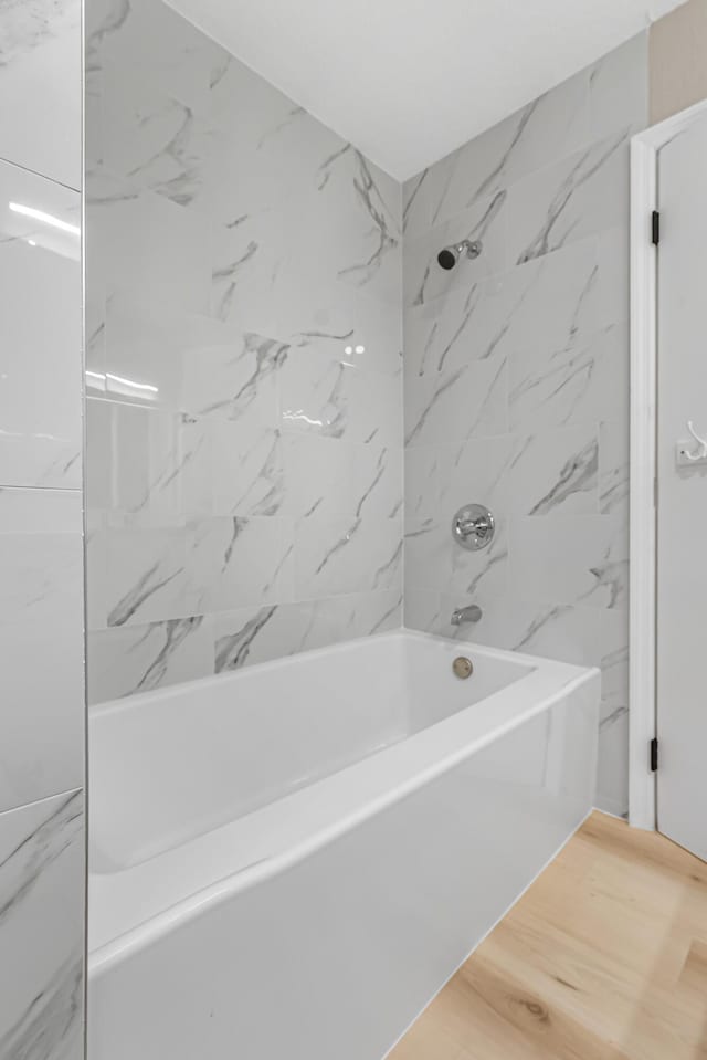 full bath featuring wood finished floors and tub / shower combination