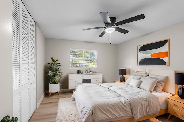 bedroom with a closet, ceiling fan, baseboards, and light wood-type flooring
