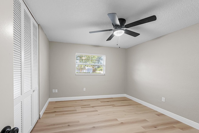 unfurnished bedroom with baseboards, a ceiling fan, light wood-style floors, and a closet