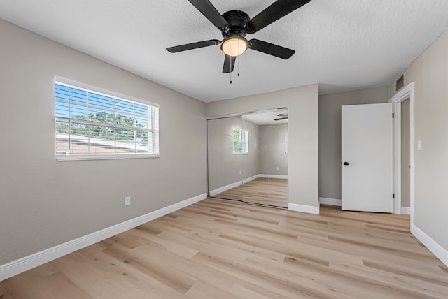 unfurnished bedroom featuring baseboards, a closet, visible vents, and light wood-type flooring
