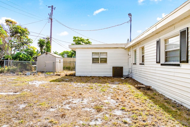 view of yard with cooling unit, an outbuilding, a shed, and a fenced backyard