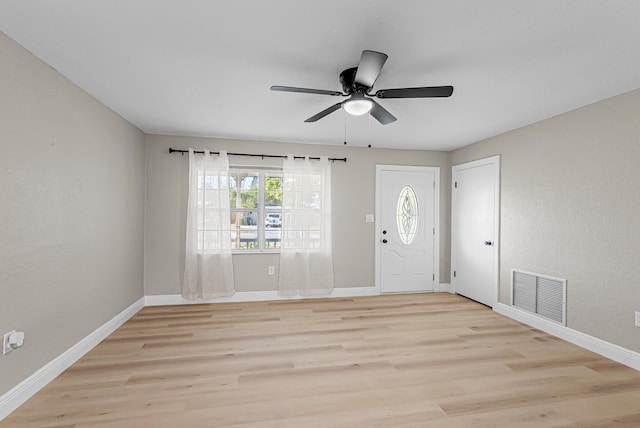 foyer with light wood finished floors, visible vents, ceiling fan, and baseboards