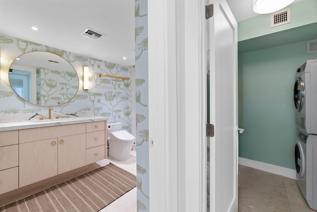 2773 S Ocean Blvd Unit 209, Palm Beach, FL 33480 - bathroom featuring toilet, stacked washer / drying machine, wallpapered walls, visible vents, and vanity