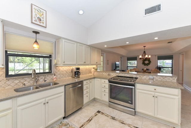 kitchen featuring stainless steel appliances, a sink, a peninsula, tasteful backsplash, and recessed lighting