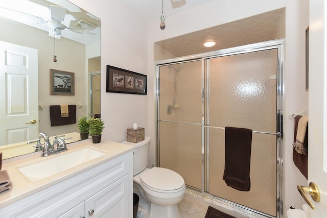 bathroom with a shower stall, toilet, vanity, and tile patterned flooring