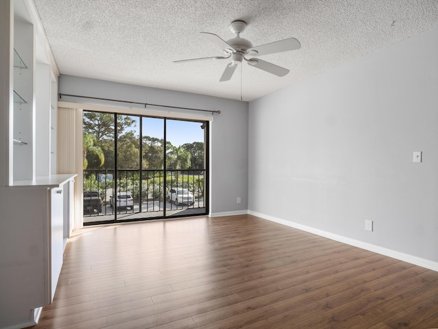 empty room featuring ceiling fan, a textured ceiling, wood finished floors, and baseboards