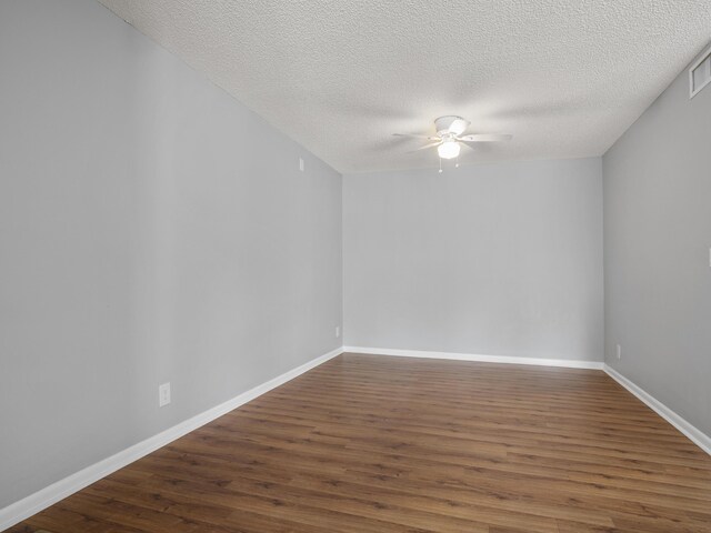 unfurnished room featuring ceiling fan, wood finished floors, baseboards, and a textured ceiling