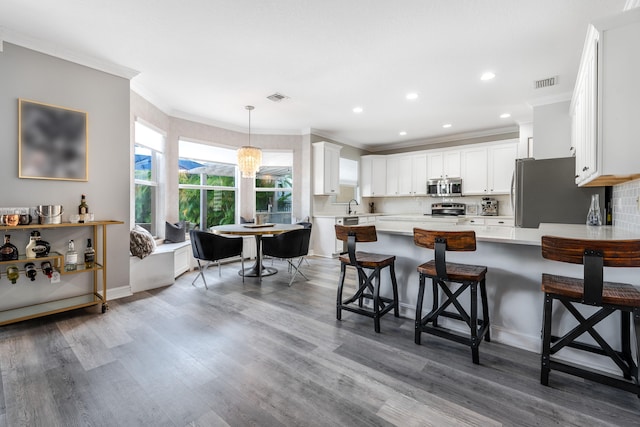 8533 Briar Rose Pt, Boynton Beach, FL 33473 - kitchen featuring stainless steel appliances, a peninsula, light countertops, recessed lighting, and ornamental molding