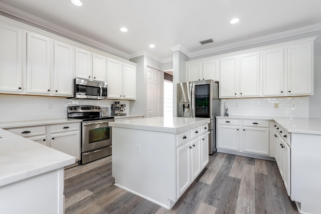 8533 Briar Rose Pt, Boynton Beach, FL 33473 - kitchen featuring stainless steel appliances, a kitchen island, crown molding, wood finished floors, and tasteful backsplash