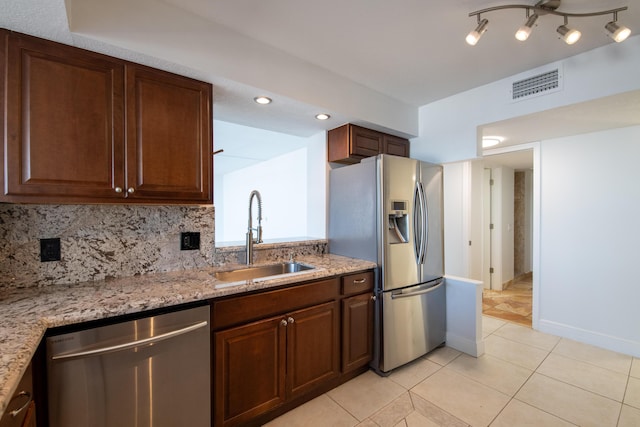 kitchen featuring light tile patterned floors, a sink, appliances with stainless steel finishes, visible vents, and light stone countertops