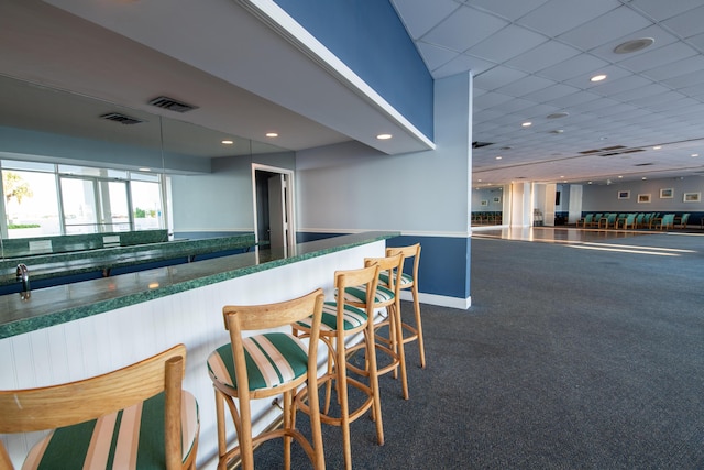 bar featuring dark carpet, visible vents, recessed lighting, and baseboards