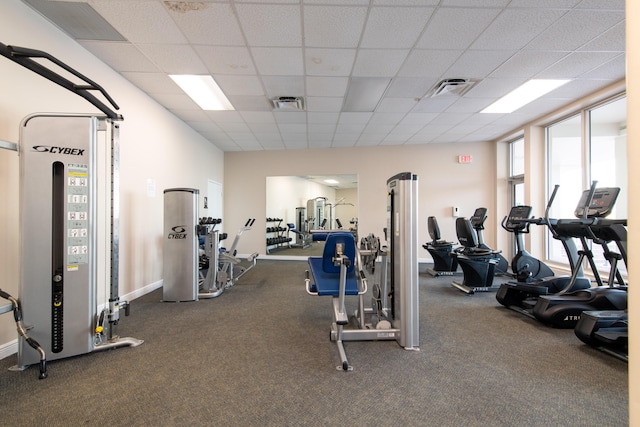 workout area featuring baseboards, visible vents, carpet, and a drop ceiling