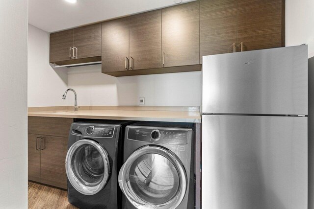 7383 Orangewood Ln Unit 304, Boca Raton, FL 33433 - laundry area with washing machine and clothes dryer, light wood finished floors, and a sink