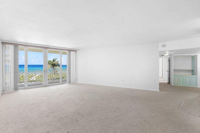 1225 S Ocean Blvd Unit 302, Delray Beach, FL 33483 - carpeted empty room featuring a water view and baseboards