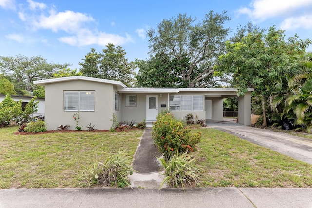 ranch-style home featuring a carport, stucco siding, a front yard, and concrete driveway