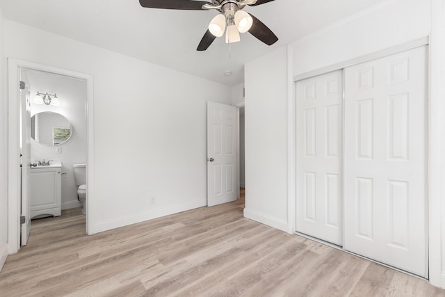 unfurnished bedroom featuring connected bathroom, a closet, a sink, and light wood-style flooring