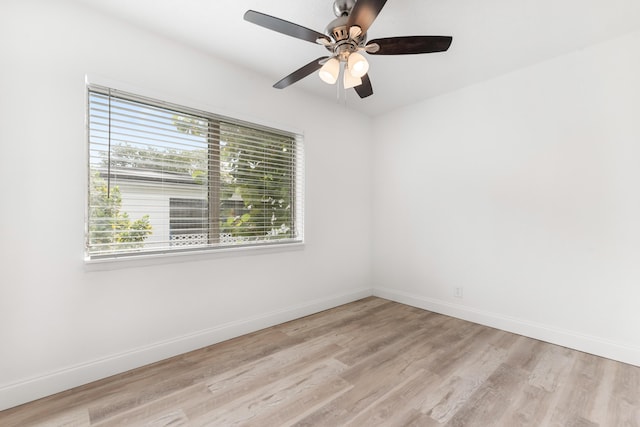 spare room with ceiling fan, baseboards, and light wood-style floors
