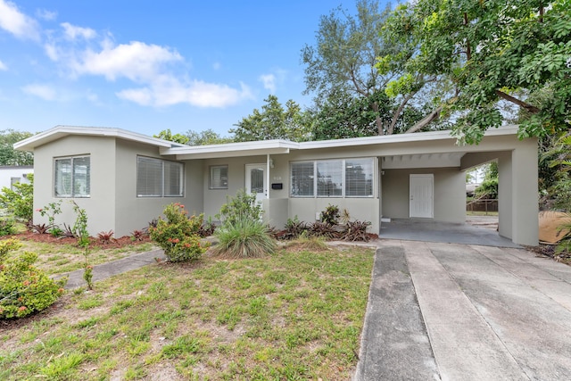 ranch-style house with stucco siding, driveway, and a carport