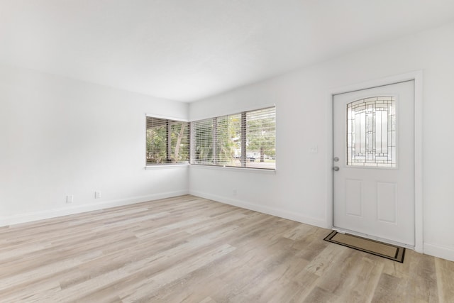 foyer with light wood finished floors and baseboards