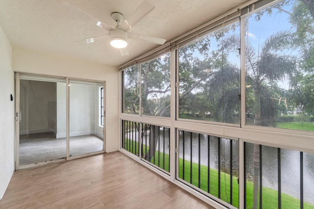 7350 Kinghurst Dr Unit 305, Delray Beach, FL 33446 - unfurnished sunroom with wood finished floors, a textured ceiling, and a water view